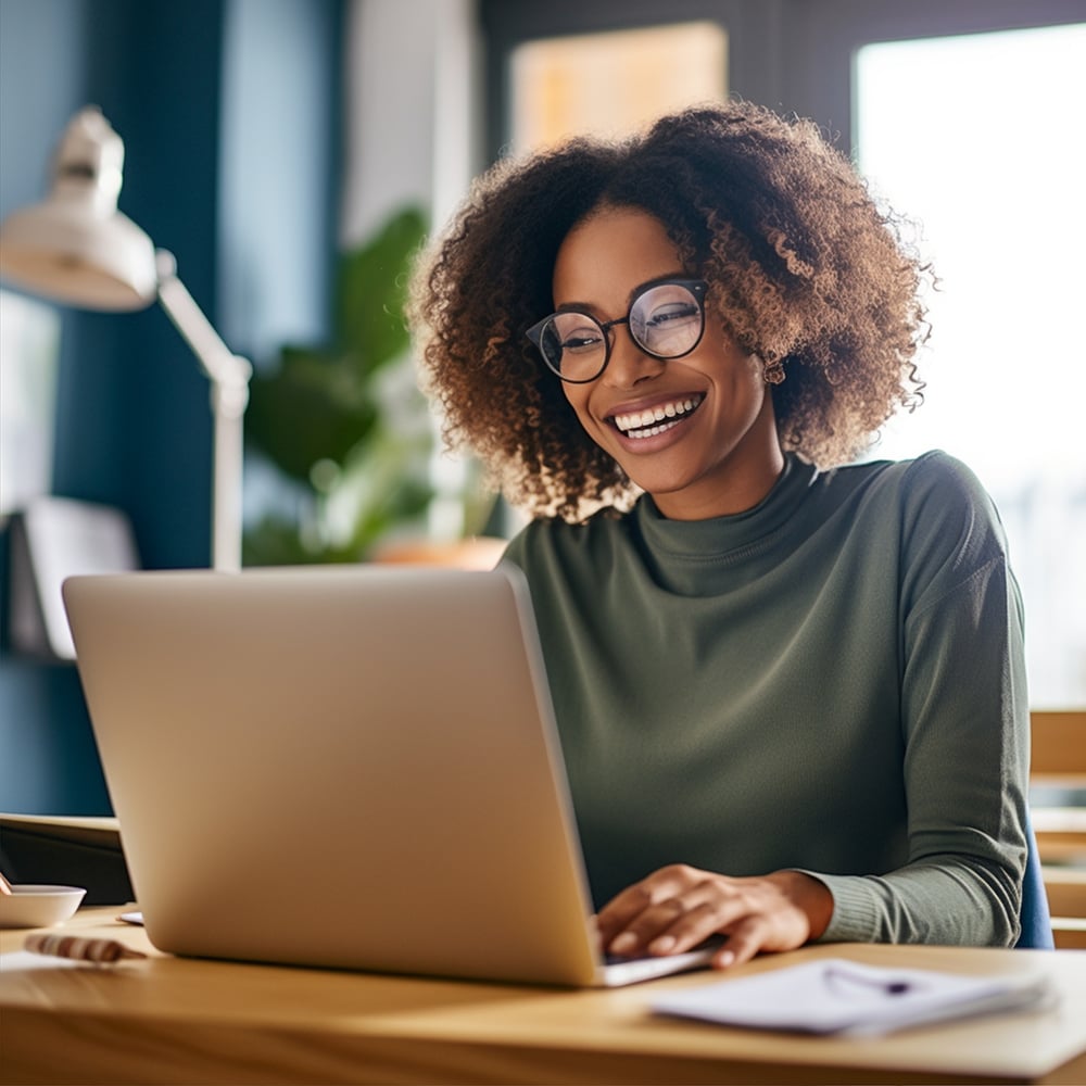 Young black woman smiling while working on computer Young black woman smiling while working on computer